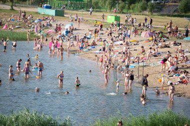 25 Temmuz 2021 Belarus, Gomil. Gölün kıyısında bir sahil. Sıcak bir günde sahilde bir sürü insan var..