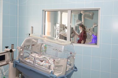 Yeni doğmuş bir bebek bir kuvözde tedavi edilir. Yenidoğan canlandırma bölümü, prematüre bebekler için yoğun bakım ünitesi..