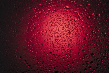 Kırmızı zemin üzerindeki cama su damlıyor..