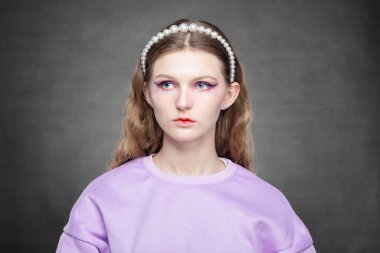 Gri bir arka planda mor uzun kollu kız modeli.