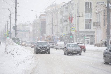 Belarus, Gomil, 11 Şubat 2021. Kışın şehir sokakları. Karlı şehirde arabalar sürüyor..