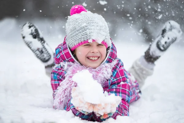 Mutlu kız kar atıyor. Çocuk kışın ve ilk karın keyfini çıkarır..