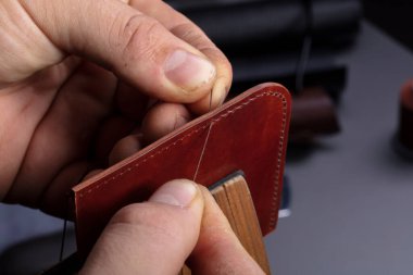 Deri cüzdan yapıyorum. Ustanın elleri deri bir ürün dikiyor..