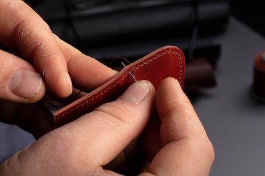 Deri cüzdan yapıyorum. Ustanın elleri deri bir ürün dikiyor..
