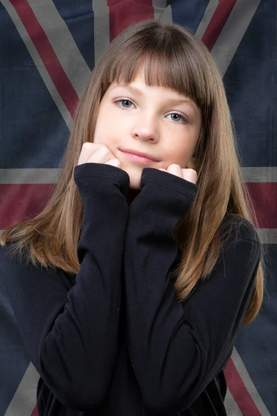 英国の国旗がぼやけている背景に立って 甘い笑顔の美しい少女 — ストック写真
