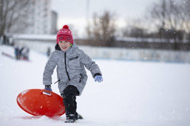 Child in winter. The boy is sledding.