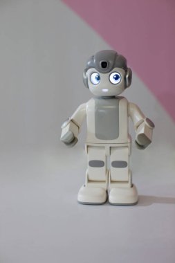 Gri arka planda küçük bir robot figürü.