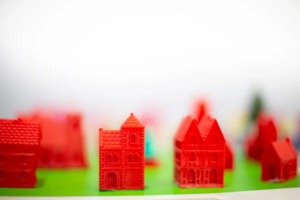 Red Figures Blurred Plastic Houses White Background — Stock Photo, Image