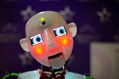 Mavi arka planda turuncu ışıkla aydınlatılmış komik robot yüzü.