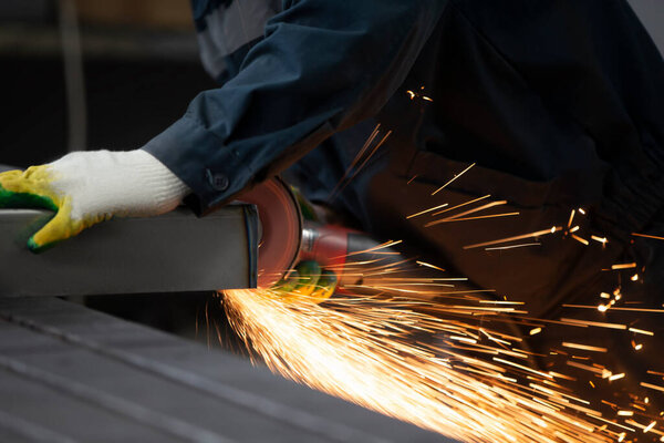 The welder cuts the pipe and fiery sparks fly.Worker cuts gas pipe with grinder, close up