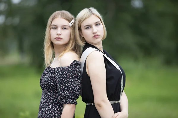 Две Сестры Красивые Молодые Девушки Стоят Спиной Друг Другу — стоковое фото