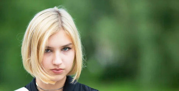 Blonde face on a green background. Seventeen year old girl.