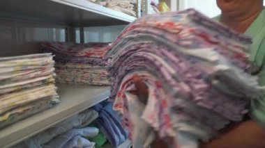 The nurse folds the hospital linen.