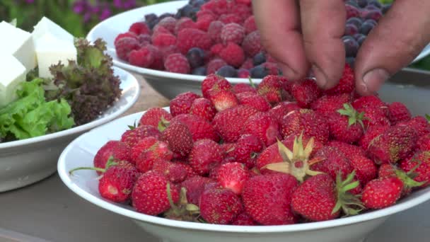 Die Hand Eines Mannes Nimmt Erdbeeren Von Einem Teller Der — Stockvideo