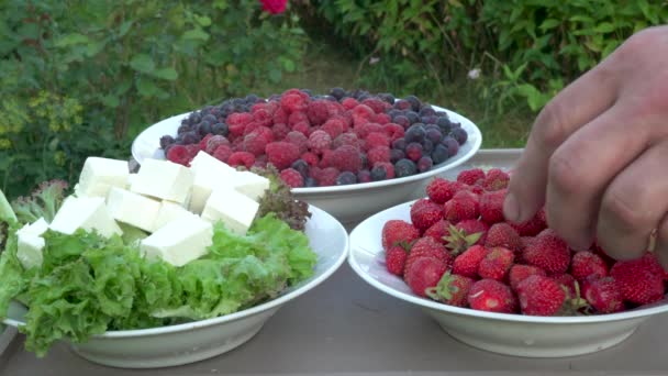 Die Hand Eines Mannes Nimmt Erdbeeren Von Einem Teller Der — Stockvideo