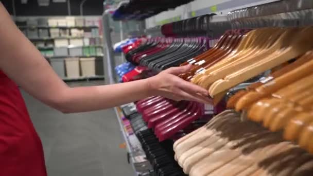 Beautiful Elderly Woman Sorts Empty Clothes Hangers Store — 图库视频影像