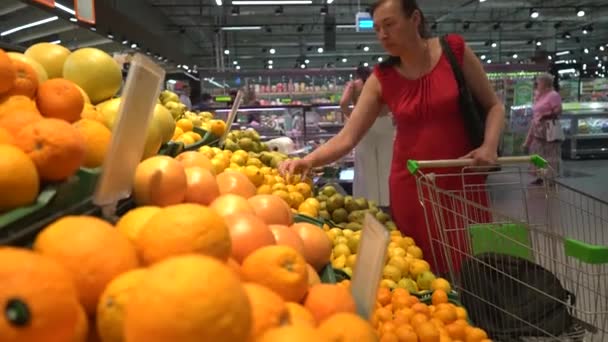 Una Hermosa Mujer Empuja Una Canasta Toma Fruta Los Estantes — Vídeos de Stock