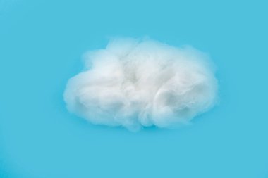 White piece of cotton wool on a blue background. Delicate cloud.Piece Cotton wool isolated on blue