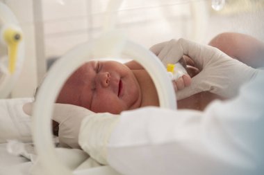 A newborn baby lies in boxes in the hospital. A child in an incubator. Neonatal and Premature Intensive Care Unit