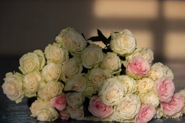 Bouquet of white roses close-up in beige tones.