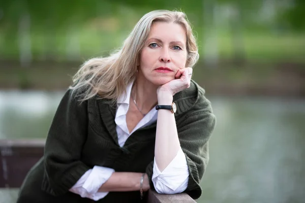 Portrait of a beautiful elderly blonde woman of European appearance. Fifty-year-old woman close-up on a natural background