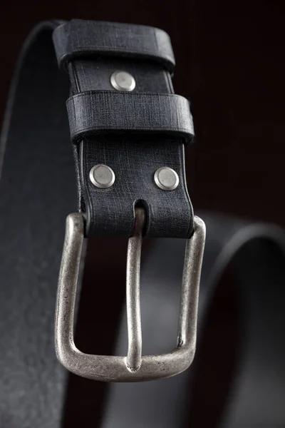 Black leather belt on a dark background. Leather products.