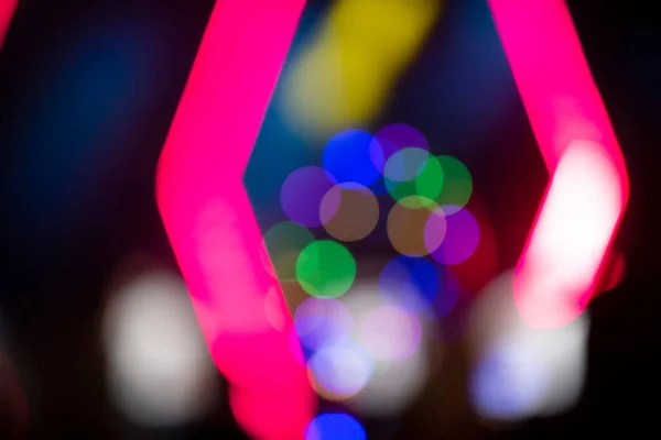 Multi-colored bokeh spots on a dark background. Festive blurred background.