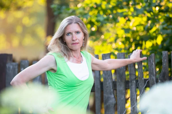 Portrait of a beautiful elderly blonde woman outdoors.