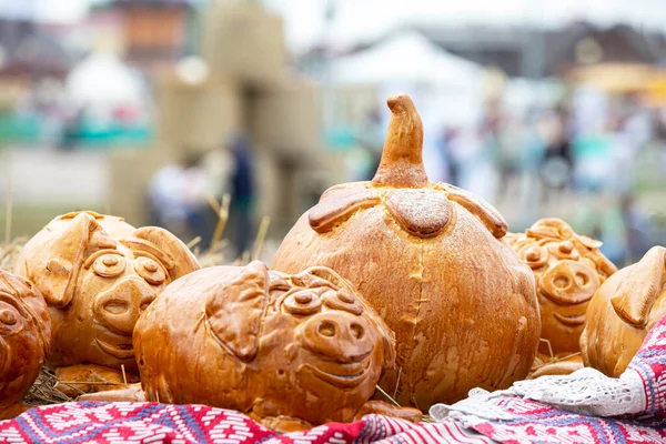 Rural autumn fair. Halloween pastries. Buns in the form of a pumpkin and pigs.
