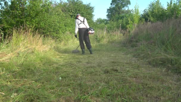 Bir Adam Benzin Tırpanıyla Çim Biçiyor — Stok video