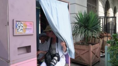 People take selfies in a photo booth on the streets of Batumi. Georgia. August 10, 2022.