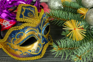 Ladin dalları, altın Venedik maskesi, toplar. Noel ve Yeni Yıl kavramı.