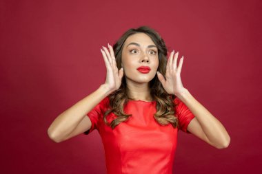 Surprised woman on a red background.