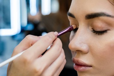 Güzel esmer bir kadın, güzellik salonunda renkli gözkapakları takar..