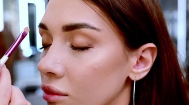 Güzel esmer bir kadın, güzellik salonunda renkli gözkapakları takar..