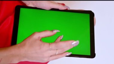Kadın elleri yeşil ekran ile tablet üzerindeki dokunmatik panele bastırma simülasyonu yapar.