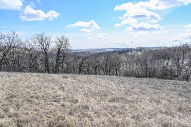 Dağlar, bozkırlar, kar, çalılar, çimenler ve bulutlu gökyüzü. Volga Nehri kıyısında. Bahar manzarası.