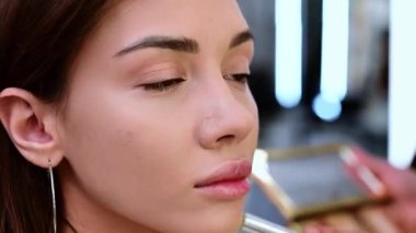 Güzel esmer kadın, bir güzellik salonunda fırçayla tozlanmış ve tonlanmış..