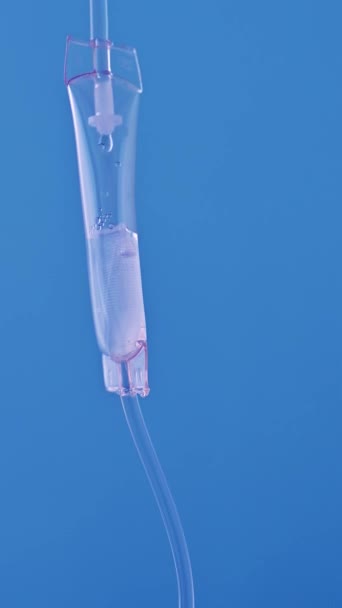 Detailní záběr intravenózní kapačky v nemocnici, Intravenózní roztok fyziologického roztoku, intravenózní nasycovací dávka. Modré pozadí. — Stock video