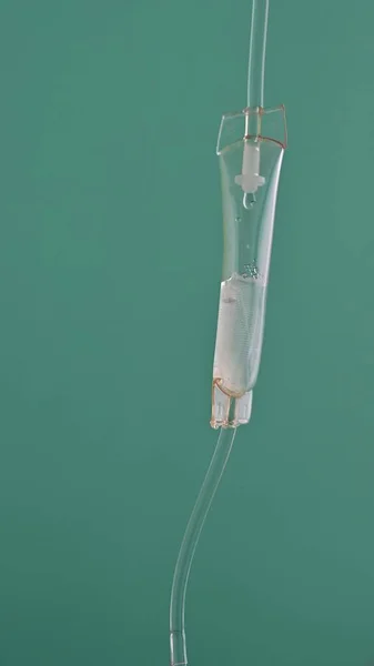 Close-up of intravenous drip in hospital, Intravenous saline solution, intravenous loading dose on the green background.
