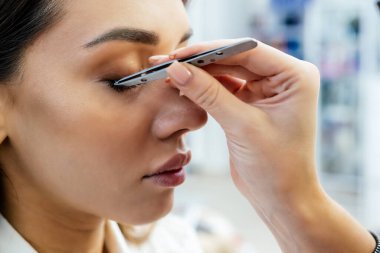 Güzel esmer kadının güzellik salonunda kirpik uzantıları var..