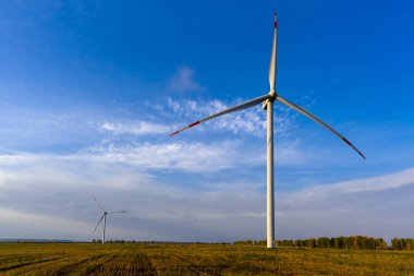 Sabahın köründe rüzgar türbinleri. Alternatif çevre dostu enerji kaynakları. Rüzgar jeneratörü mavi gökyüzüne ve yeşil çimenlere yakın çekim yapıyor.. 