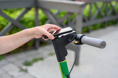 Bir kadın telefonu Kazan seti üzerinde scooter kiralıyor. Çevre dostu nakliye aracı. Etkin yaşam biçimi.