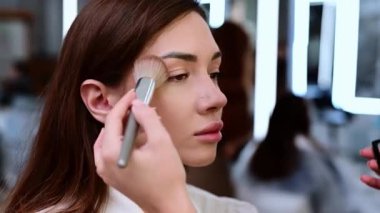 Güzel esmer kadın, bir güzellik salonunda fırçayla tozlanmış ve tonlanmış..