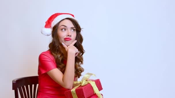 Beautiful Woman Sits Chair Christmas Cap Gift Showing Bewildered Emotions — Stock Video