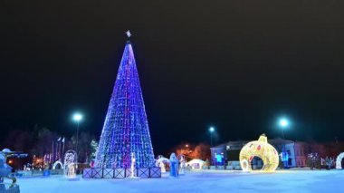 Noel ağacı yanıp sönen ampullerle süslenmiş çelenkler, noel baloları, Noel Baba, kar yağan kar kızıyla süslenmiş. Mutlu yıllar festival havası. Pozitif duygu.