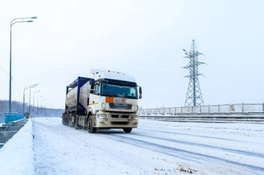 Tankı, kamyoneti, traktör ünitesi ve yük taşımak için yarı karavanı olan bir yük kamyonu. Kargo taşımacılığı sert kış koşullarında kaygan, buzlu ve karlı yollarda.