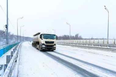 Tankı, kamyoneti, traktör ünitesi ve yük taşımak için yarı karavanı olan bir yük kamyonu. Kargo taşımacılığı sert kış koşullarında kaygan, buzlu ve karlı yollarda.
