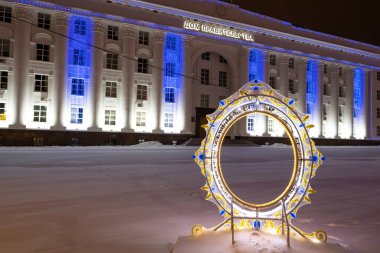Ulyanovsk, Rusya - 14 Şubat 2022: Yeni Yıl kemeri yakın planda aydınlatıldı ve hükümet binası şehrin karla kaplı merkez meydanında. Yazının çevirisi: Hükümet Binası
