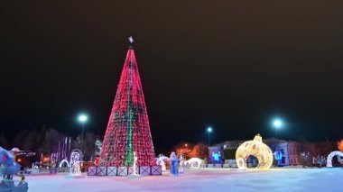 Noel ağacı yanıp sönen ampullerle süslenmiş çelenkler, noel baloları, Noel Baba, kar yağan kar kızıyla süslenmiş. Mutlu yıllar festival havası. Pozitif duygu.